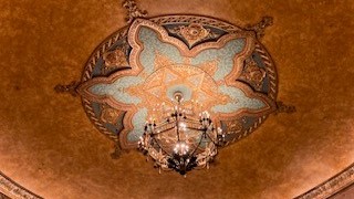 Close up of ceiling with a mosaic and chandelier 