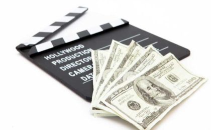 Hundred dollar bills on top of a movie 'slate'