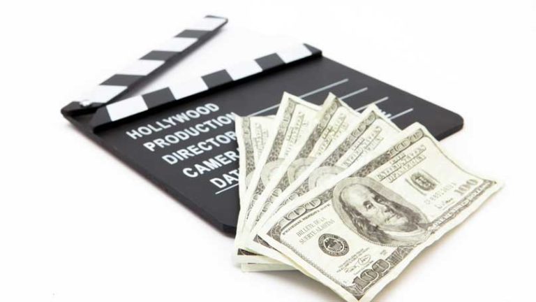 Hundred dollar bills on top of a movie 'slate'