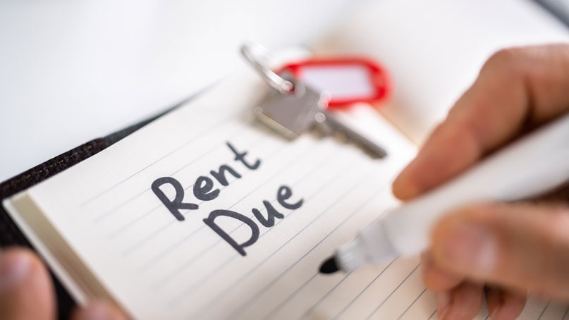 Handwritten note that says Rent Due with a room key on top