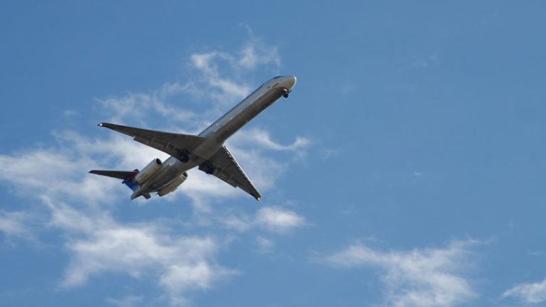 close up view of airplane in the sky, from below