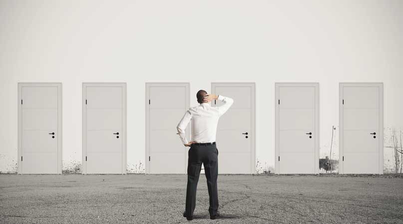 Man looking at several doors as he considers career options