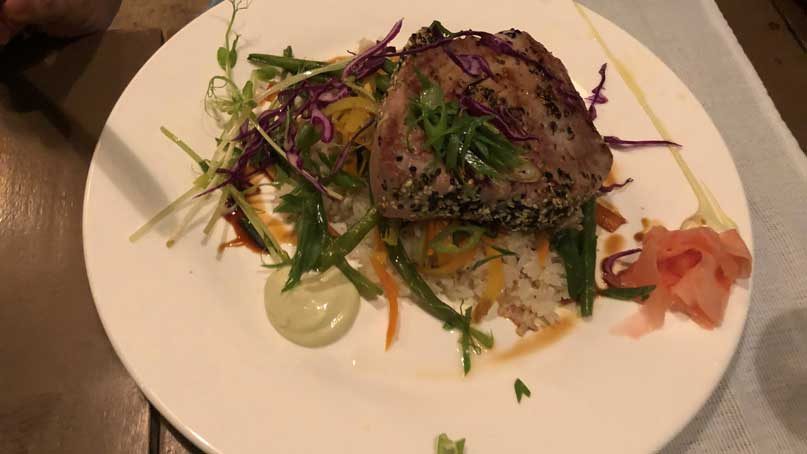 plate of yellowfin tuna over rice and veggies