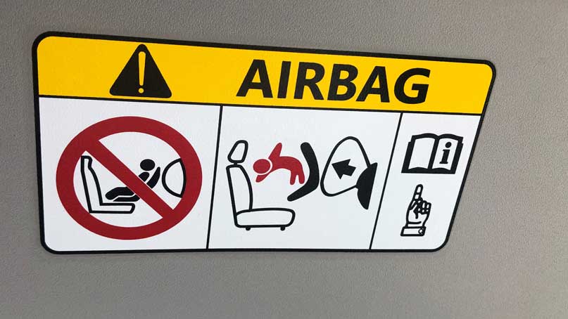 airbag sign in car with image of baby flying in the air
