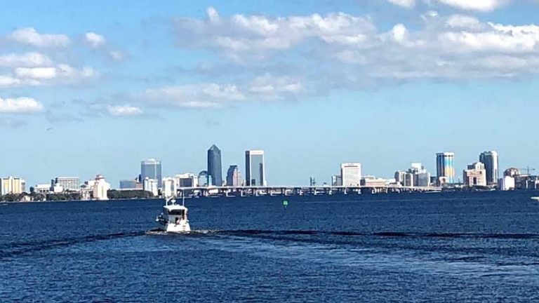 city in the distance with water and boat in the foreground