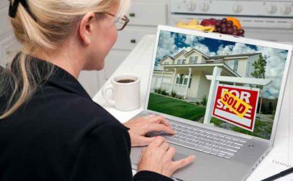 woman looking at houses on a laptop