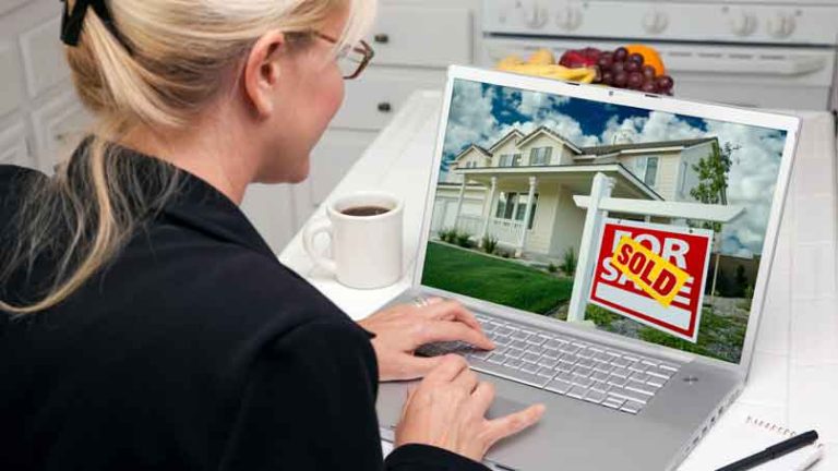 woman looking at houses on a laptop