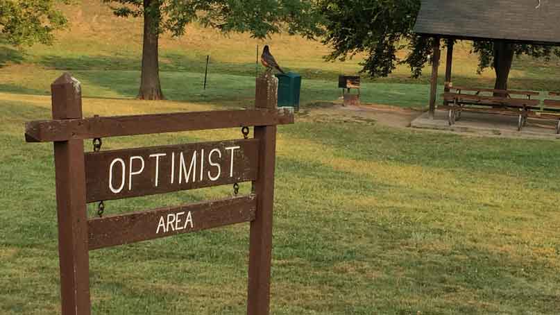 sign in a park that says 'optimist area'