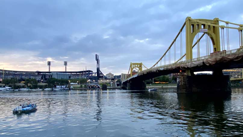 Bridge over a river with a stadium on the other side