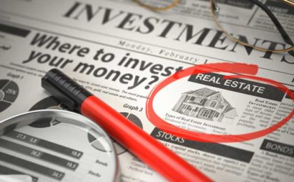 investing newspaper with real estate in a circle