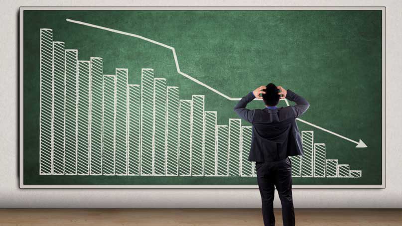 man in front of chart showing declining bar graph