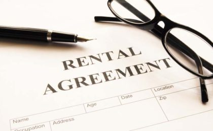 Paper that says Rental Agreement, with a pen and glasses laying on top