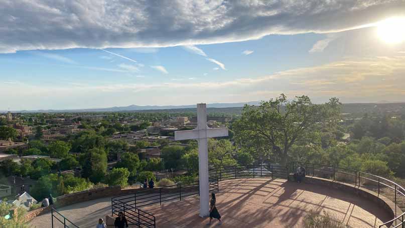 scenic overlook with large cross in front - cloud shelf, sun and blue skies above