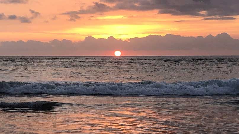 sunset over the ocean with clouds