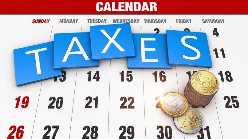 calendar showing a month with the word taxes on top and some coins
