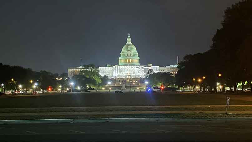 View of US Capital lit up at night from a distance