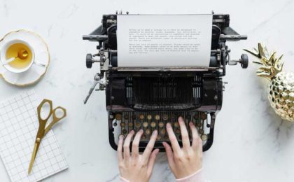 Hands typing on a typewriter